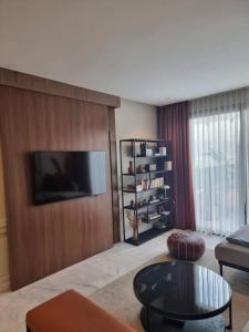 ein Wohnzimmer mit einem Flachbild-TV an einer Holzwand in der Unterkunft Superbe appartement avec terrasse in Casablanca