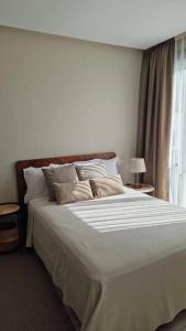 Schlafzimmer mit einem großen weißen Bett und einem Fenster in der Unterkunft Superbe appartement avec terrasse in Casablanca