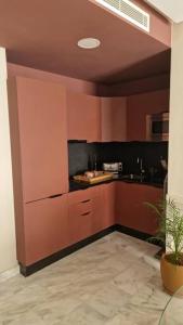 eine Küche mit braunen Schränken und einer Topfpflanze in der Unterkunft Superbe appartement avec terrasse in Casablanca