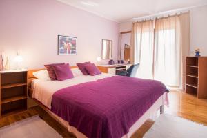 Un dormitorio con una cama grande con una manta morada. en Apartment with private pool and arbor, en Malinska 37 fotos más