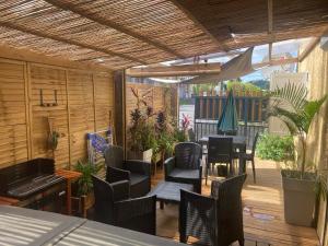 a patio with a table and chairs and plants at La Caz Anaïs avec jacuzzi in Saint-Joseph