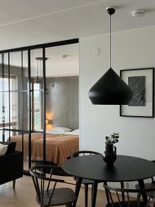 ユヴァスキュラにあるTikka Apartmentsのベッド、テーブル、椅子が備わる客室です。