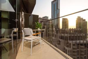 einen Balkon mit einem Tisch und Stühlen sowie eine Stadt in der Unterkunft Prime Retreats @ Address Residence Opera By Emaar in Dubai