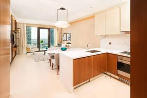 una cucina con banconi bianchi e una sala da pranzo di Prime Retreats @ Address Residence Opera By Emaar a Dubai