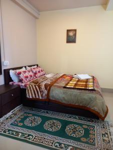 a bedroom with a bed and a rug on the floor at Cardamom Blues in Aritar