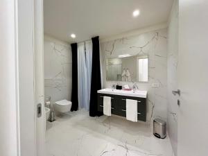 een witte badkamer met een wastafel en een toilet bij LA CASA DI ALICE in Pescantina