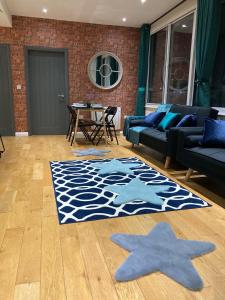 Central Sheffield 3BED 3BATH V Pent-Apartment في شيفيلد: غرفة معيشة مع أريكة زرقاء ونجوم على الأرض