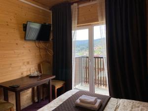 um quarto com uma cama, uma televisão e uma janela em FORREST hotel em Bukovel