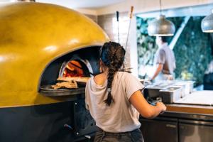 a woman standing in front of a pizza oven at LEGASEA - Cascais Guesthouse in Cascais