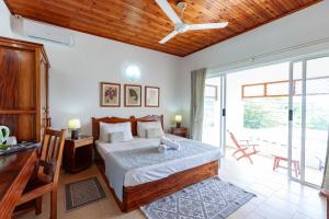 Schlafzimmer mit einem Bett und einer Glasschiebetür in der Unterkunft Villa Anse La Blague in Baie Sainte Anne