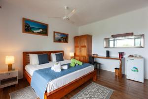 a bedroom with a bed and a desk and a refrigerator at Villa Anse La Blague in Baie Sainte Anne