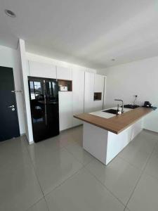 a kitchen with a sink and a black refrigerator at Superbe Penthouse Terrasse avec vue Mer in Tel Aviv