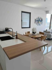 a kitchen with a counter top and a living room at Superbe Penthouse Terrasse avec vue Mer in Tel Aviv