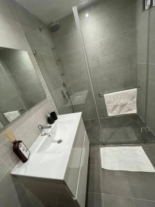 uma casa de banho com um lavatório branco e um chuveiro em Superbe Penthouse Terrasse avec vue Mer em Tel Aviv