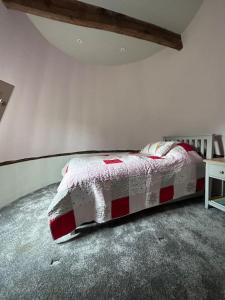 a bedroom with a bed with a red and white blanket at Beautiful 2 bed Oast - 15 acre farm - Tunbridge Wells in Royal Tunbridge Wells
