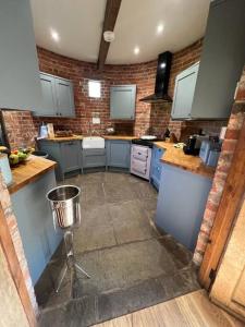 a kitchen with blue cabinets and a trash can at Beautiful 2 bed Oast - 15 acre farm - Tunbridge Wells in Royal Tunbridge Wells