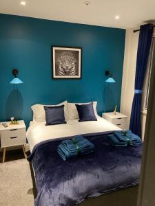 a bedroom with a large bed with blue walls at Central Sheffield 3BED 3BATH V Pent-Apartment in Sheffield