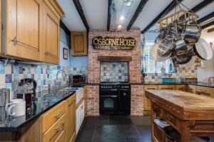 una grande cucina con muro di mattoni di Historic Osborne House very close to the beach a Looe