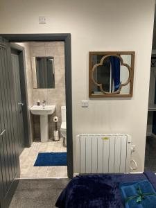 a bathroom with a sink and a toilet and a mirror at Central Sheffield 3BED 3BATH V Pent-Apartment in Sheffield