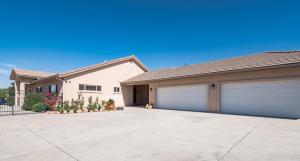 a house with two garage doors in a driveway at Prescott Luxury Home near Golf Course and Airport home in Prescott Valley