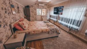 um pequeno quarto com uma cama e uma janela em White Valley entire Guest House next to Forest em Chisinau
