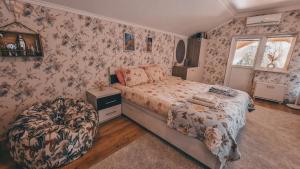 een slaapkamer met een bed en bloemenbehang bij White Valley entire Guest House next to Forest in Chişinău