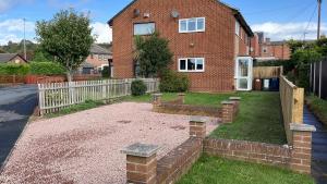 a backyard with a brick house and a fence at A modern cosy one bedroom home away from home in Houghton le Spring