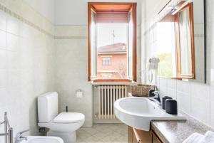 a bathroom with a toilet and a sink and a window at LOCANDA CAVALLO BIANCO - AFFITTACAMERE in Robella +20 photos