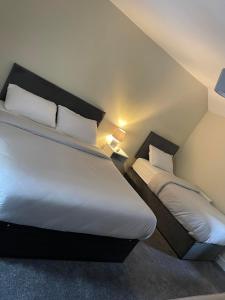 1 dormitorio con 2 camas con sábanas y almohadas blancas en The great escape en Skerries