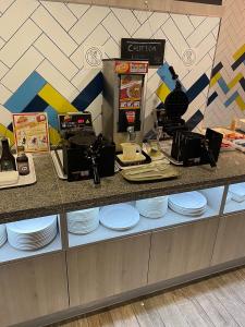 a counter with white plates and a coffee maker at Mais Banai in Mizque