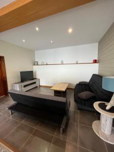 uma sala de estar com um sofá e uma mesa em la petite maisonnette em Le Plessis-Feu-Aussoux