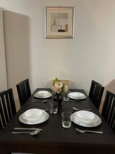 a table with plates and utensils on top of it at City Apartment - Free Parking, 3 bedrooms and 2 bathrooms in Adelaide