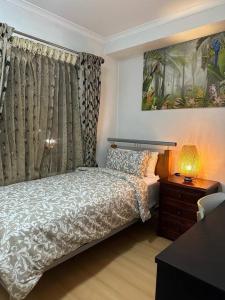 a bedroom with a bed and a table with a lamp at City Apartment - Free Parking, 3 bedrooms and 2 bathrooms in Adelaide