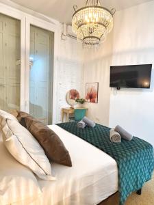 a bedroom with a large bed and a chandelier at Tennessee Studio Malaga in Málaga