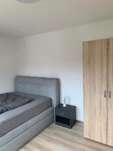 1 dormitorio con 1 cama y armario de madera en MyCha2 Ferienhaus en Goslar