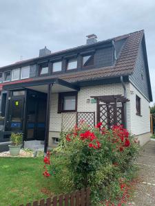 una casa con flores rojas delante de ella en MyCha2 Ferienhaus en Goslar