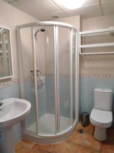 a bathroom with a shower and a toilet and a sink at La Colina Golf & Beach in Huelva