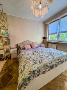 a bedroom with a bed and a chandelier at Apartment by Chopina Street in Konin