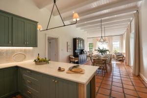 a kitchen with green cabinets and a dining room at Mount Vernon Manor in Klapmuts
