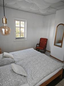 1 dormitorio con 2 camas, silla y ventana en Pension Burgenring, en Schlitz