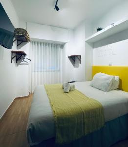um quarto com uma cama grande e uma cabeceira amarela em Local House Lisbon em Lisboa