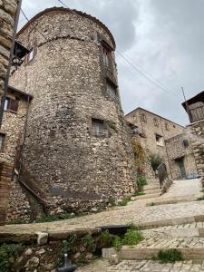 duży kamienny budynek ze schodami prowadzącymi do niego w obiekcie La “Torre dell’amore” w mieście Moricone