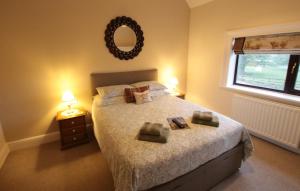 a bedroom with a bed with two towels on it at Moo Cow Cottage Self Catering in Oakham