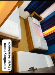 2 frigoriferi bianchi sugli scaffali in una stanza di Royal residency a Tindummal