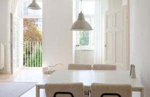 a white dining room with a white table and chairs at MINIMALISTIC STUDIO NEAR NASCHMARKT in Vienna
