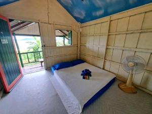 Habitación pequeña con cama y ventilador. en Neeno Hut, en Ko Chang