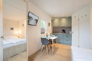 a small room with a bed and a table and a kitchen at Ostseecamp Lübecker Bucht Strandmuschel in Scharbeutz