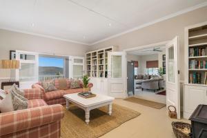 ein Wohnzimmer mit einem Sofa und einem Tisch in der Unterkunft Corner House - Knysna in Knysna