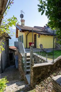 a yellow house with a gate in front of it at Casa Fausto in Vercana