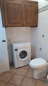 a bathroom with a washing machine and a toilet at La casa nel borgo in Bracciano